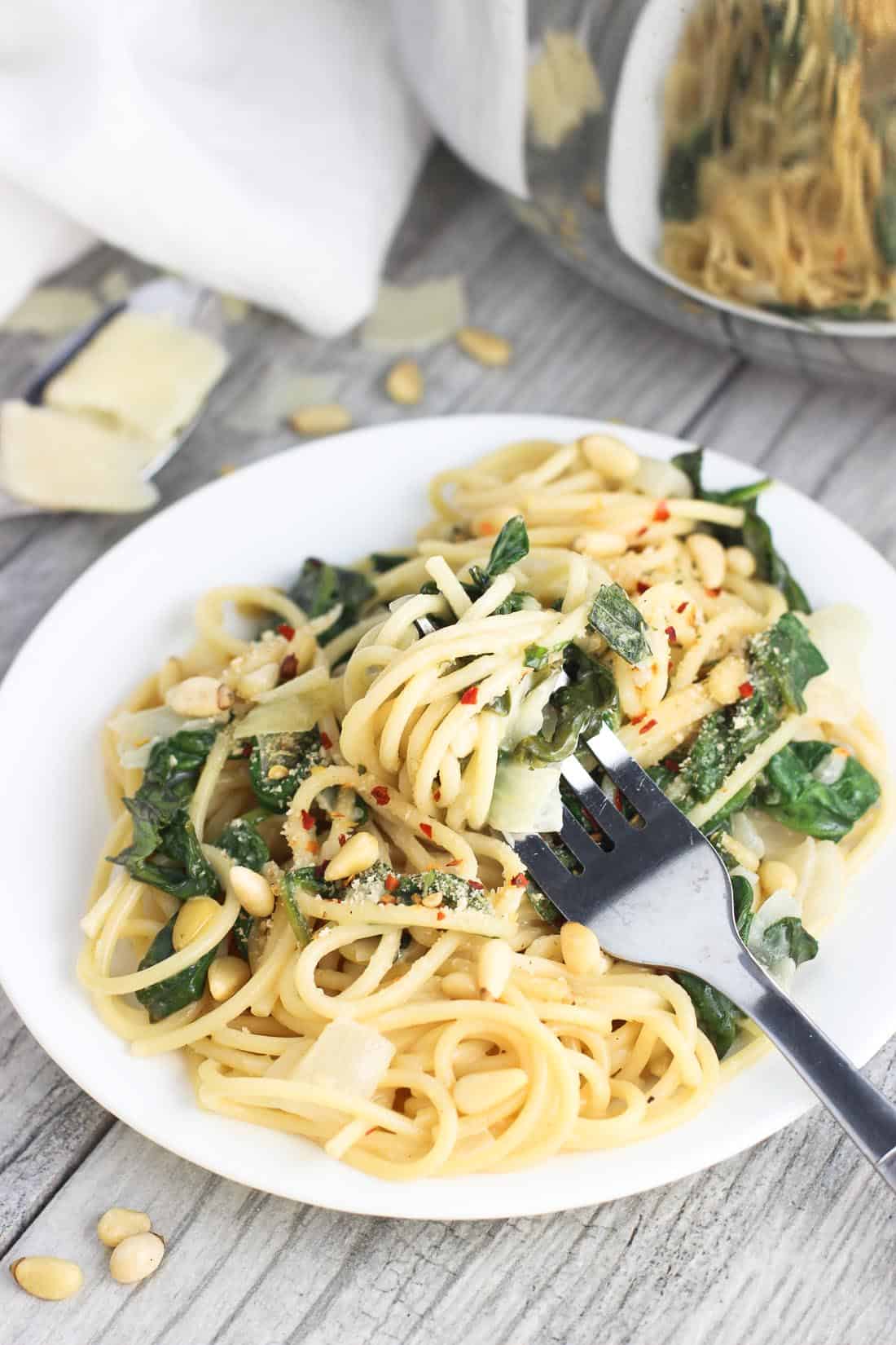 A fork twirled into a serving of pasta on a plate.