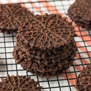 A stack of pizzelle cookies on a wire rack.