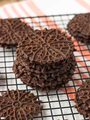 A stack of pizzelle cookies on a wire rack.