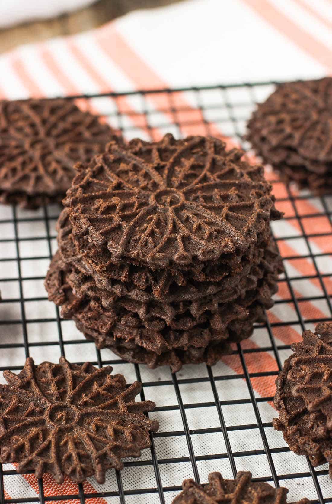 A stack of pizzelle cookies on a wire rack.