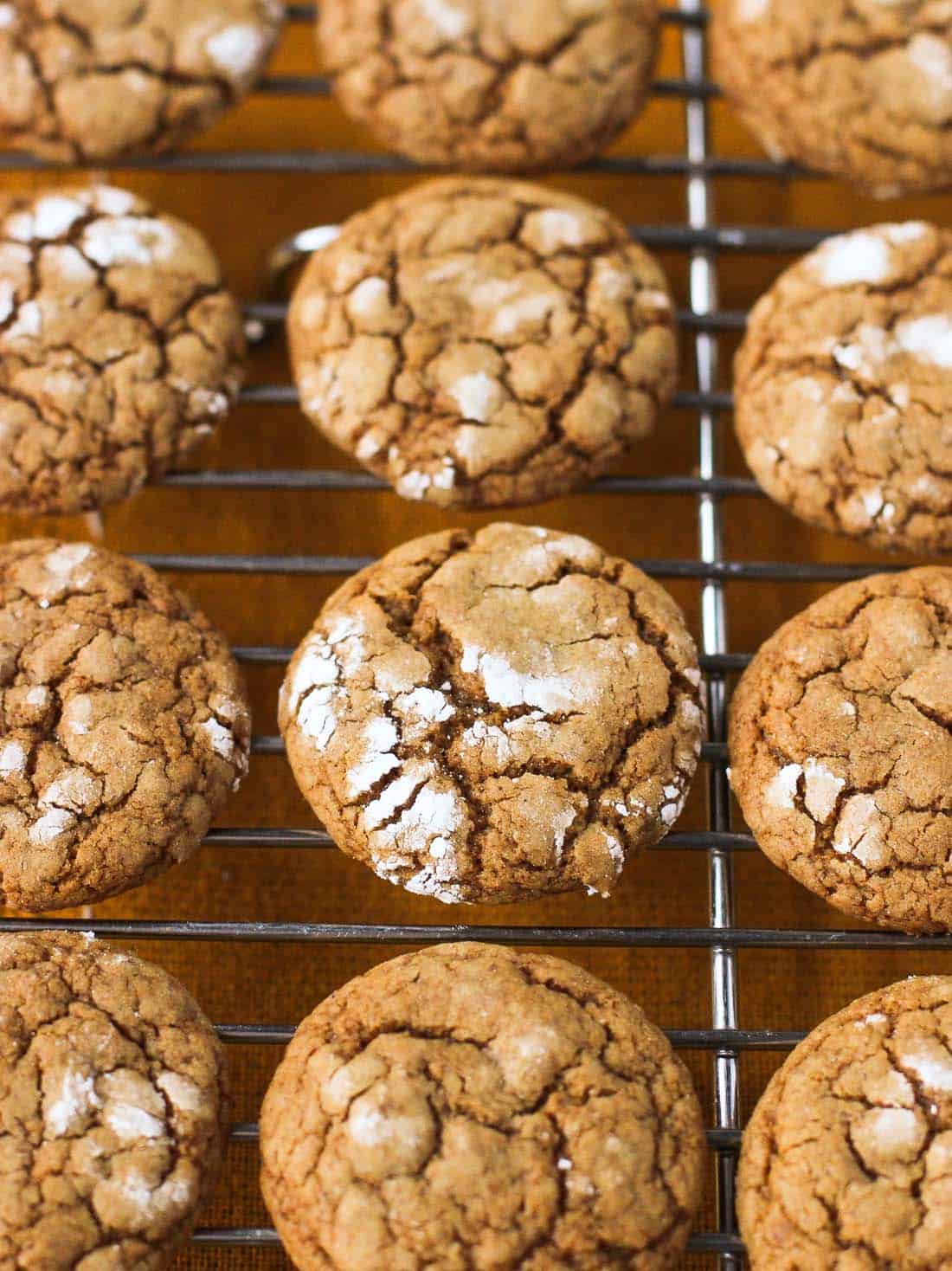 A close-up of pfeffernüsse cookies cooling on a wire rack.