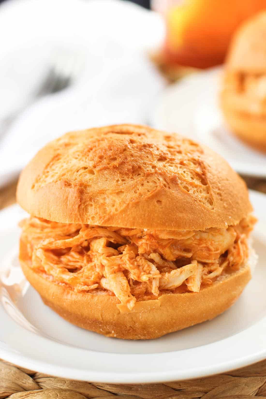 A buffalo chicken sandwich on a round roll.