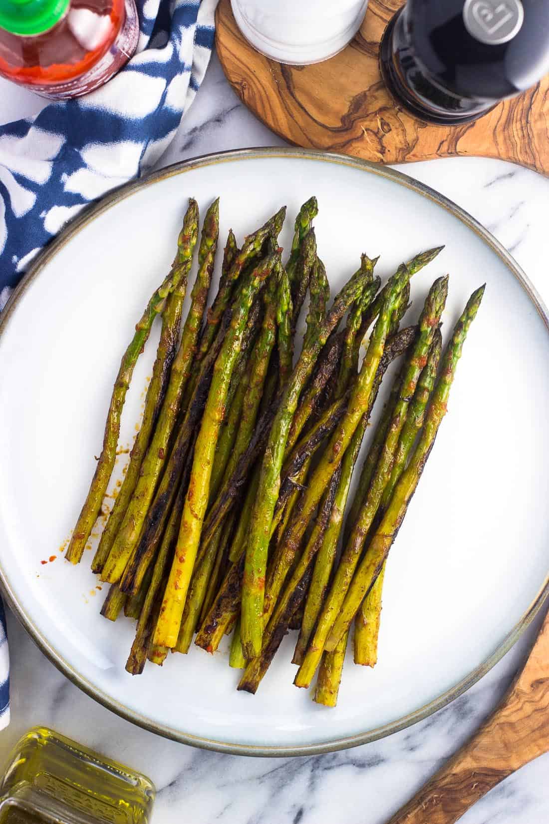 Sauteed asparagus roasted on the stovetop covered in a spicy sriracha mixture