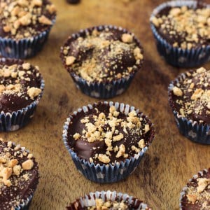 Mini s'mores cups lined up on a wooden board.