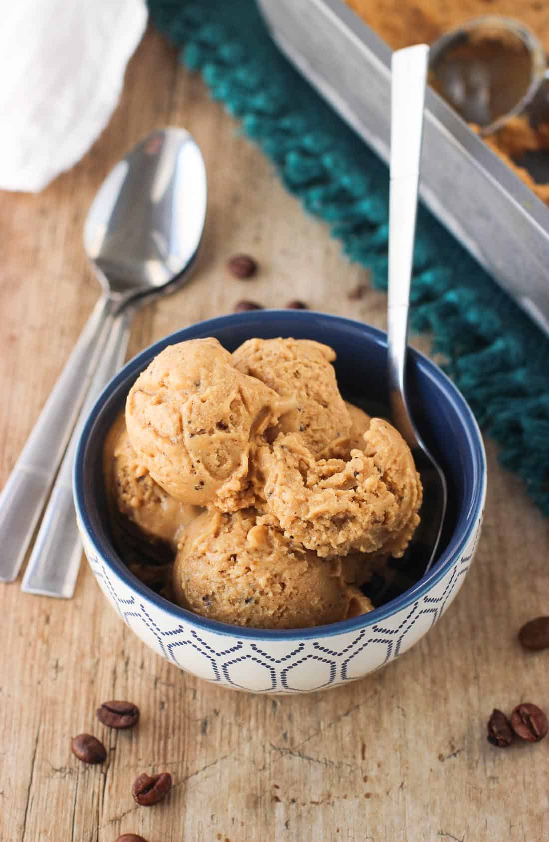 A bowl of five small scoops of ice cream with a spoon