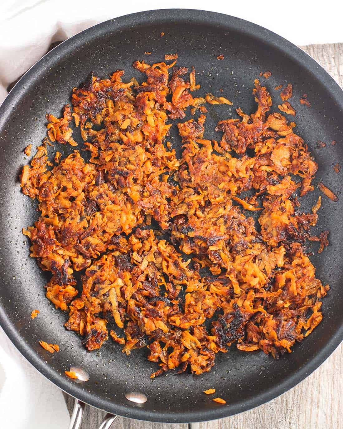 Shredded sweet potato hash browns cooked in a skillet.