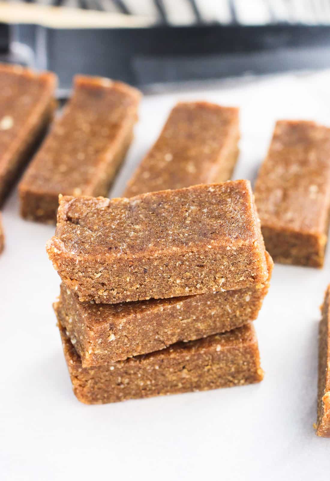 A stack of coconut almond energy bars on a cutting board