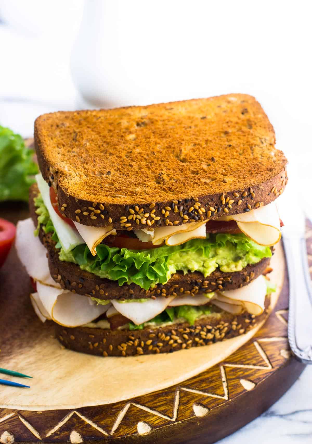 The assembled sandwich on a wooden board before being sliced.