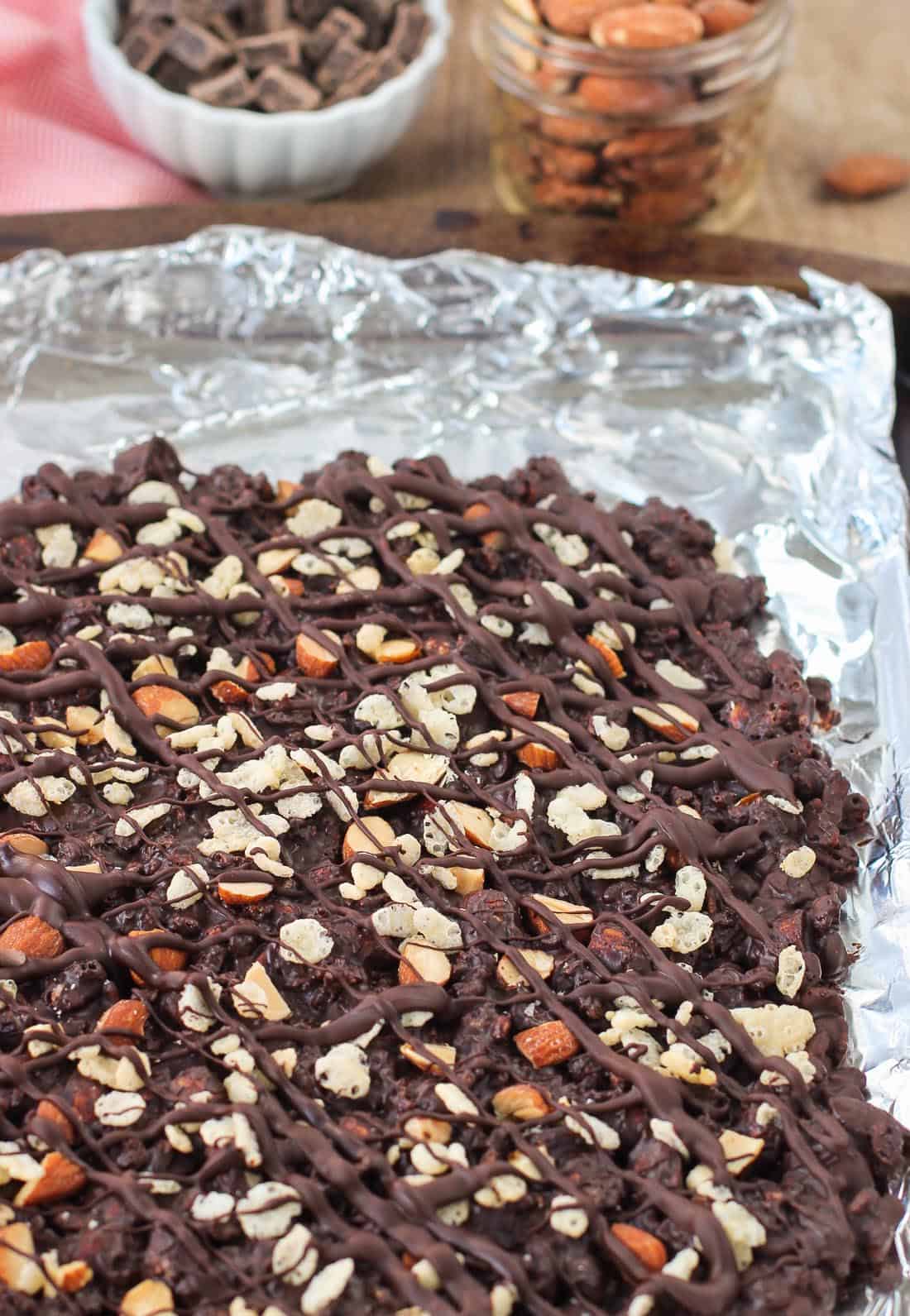 A slab of chocolate bark on an aluminum foil-lined baking sheet before cutting it into slices