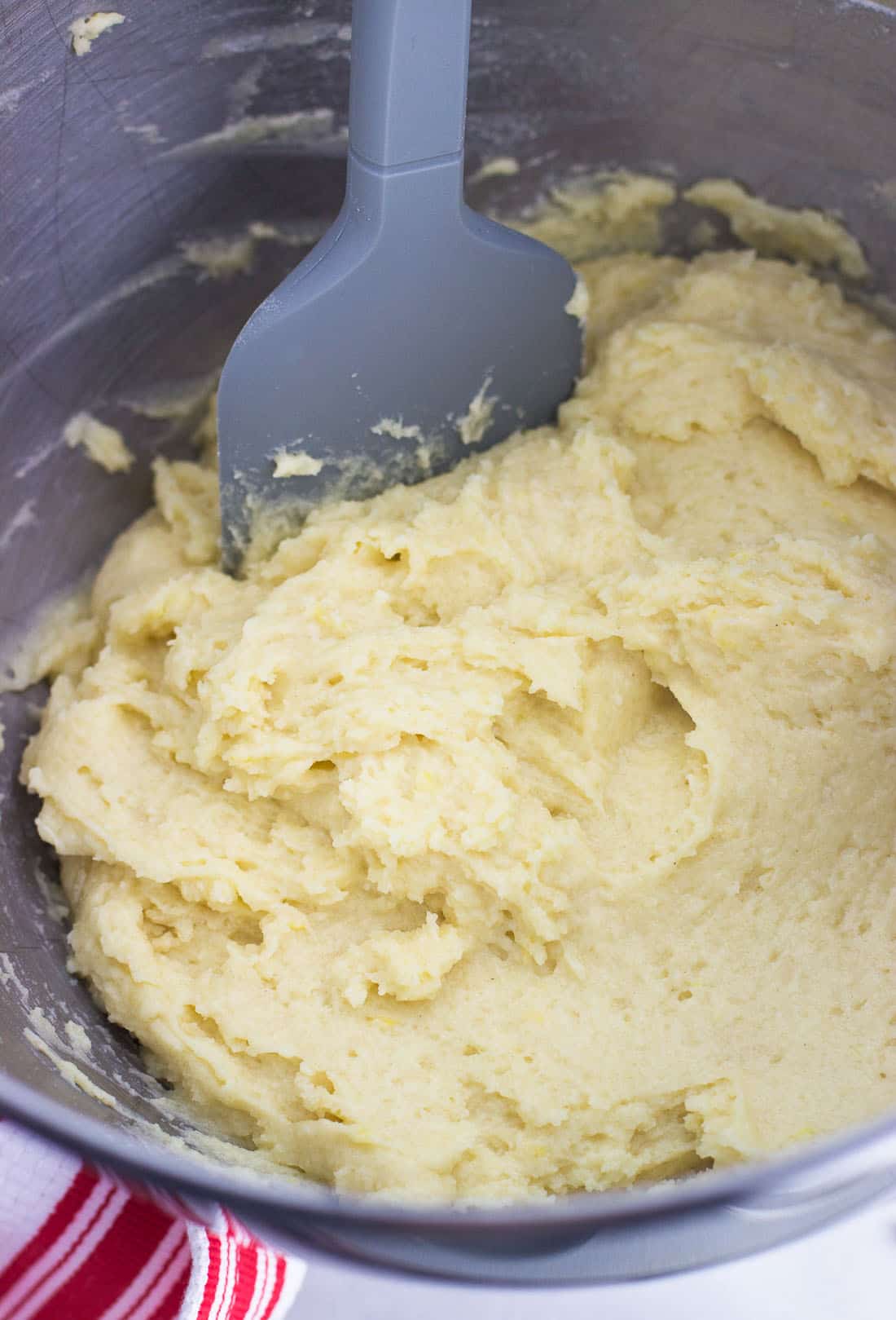 Muffin batter in a metal mixing bowl with a spatula.