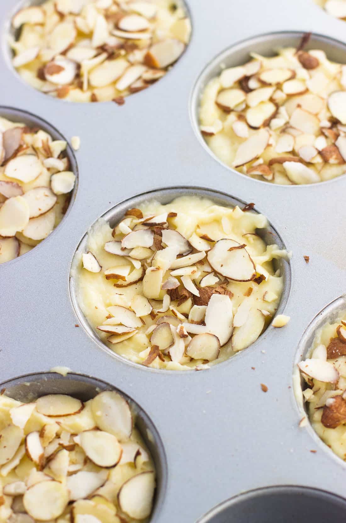 Lemon ricotta muffins in a metal muffin tin before being baked.