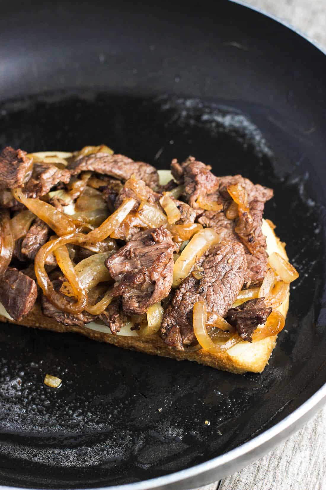 An open-face panini in a skillet.