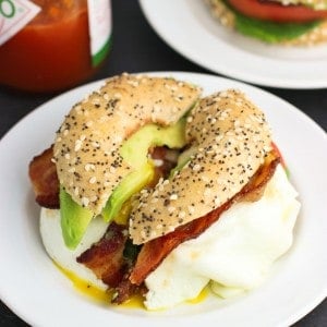 A BLT breakfast sandwich cut in half on a small plate.