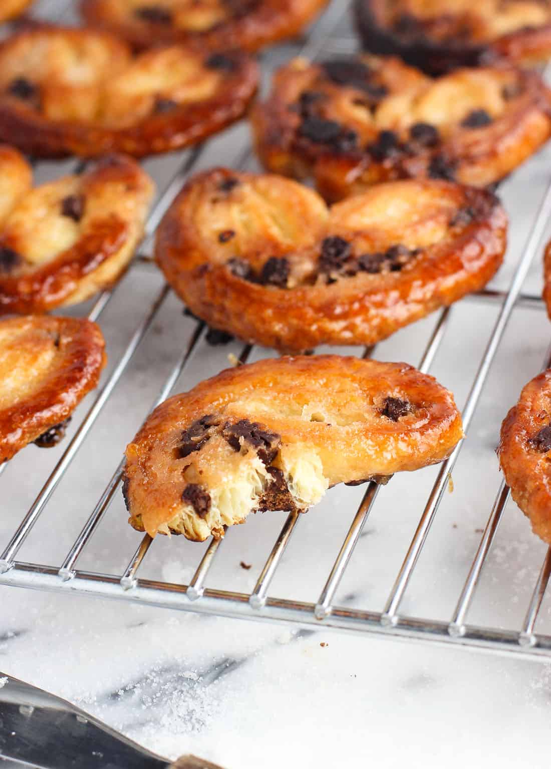 A palmier cookie broken in half on a wire rack