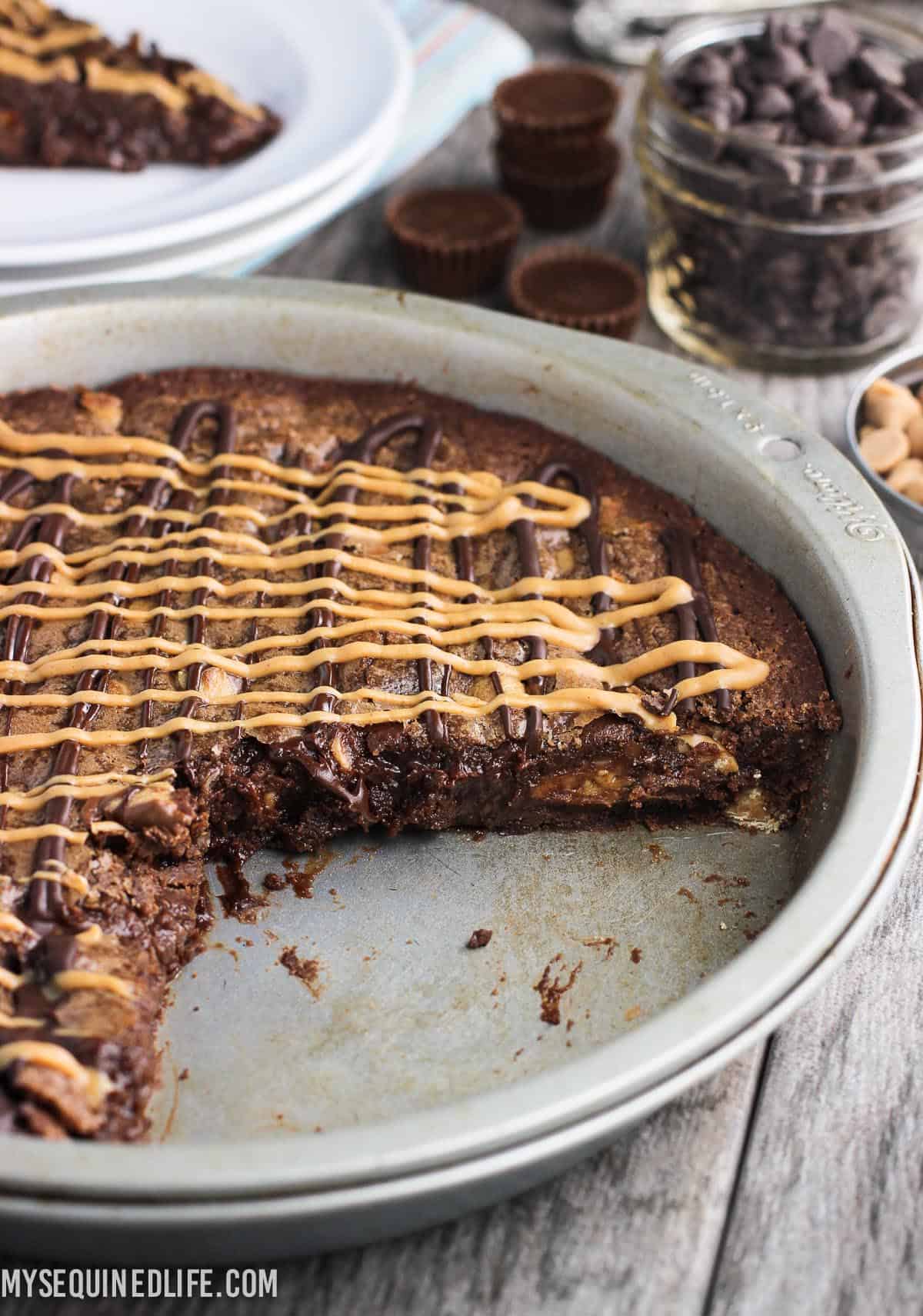 A wedge removed from the brownie cake in its pan.