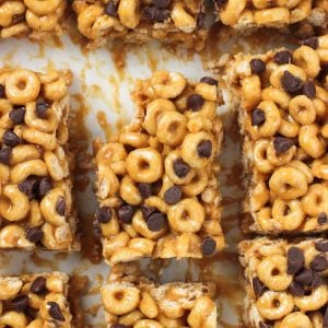 An overhead shot of cereal bars sliced on a board with a bite taken out of the corner of the middle bar