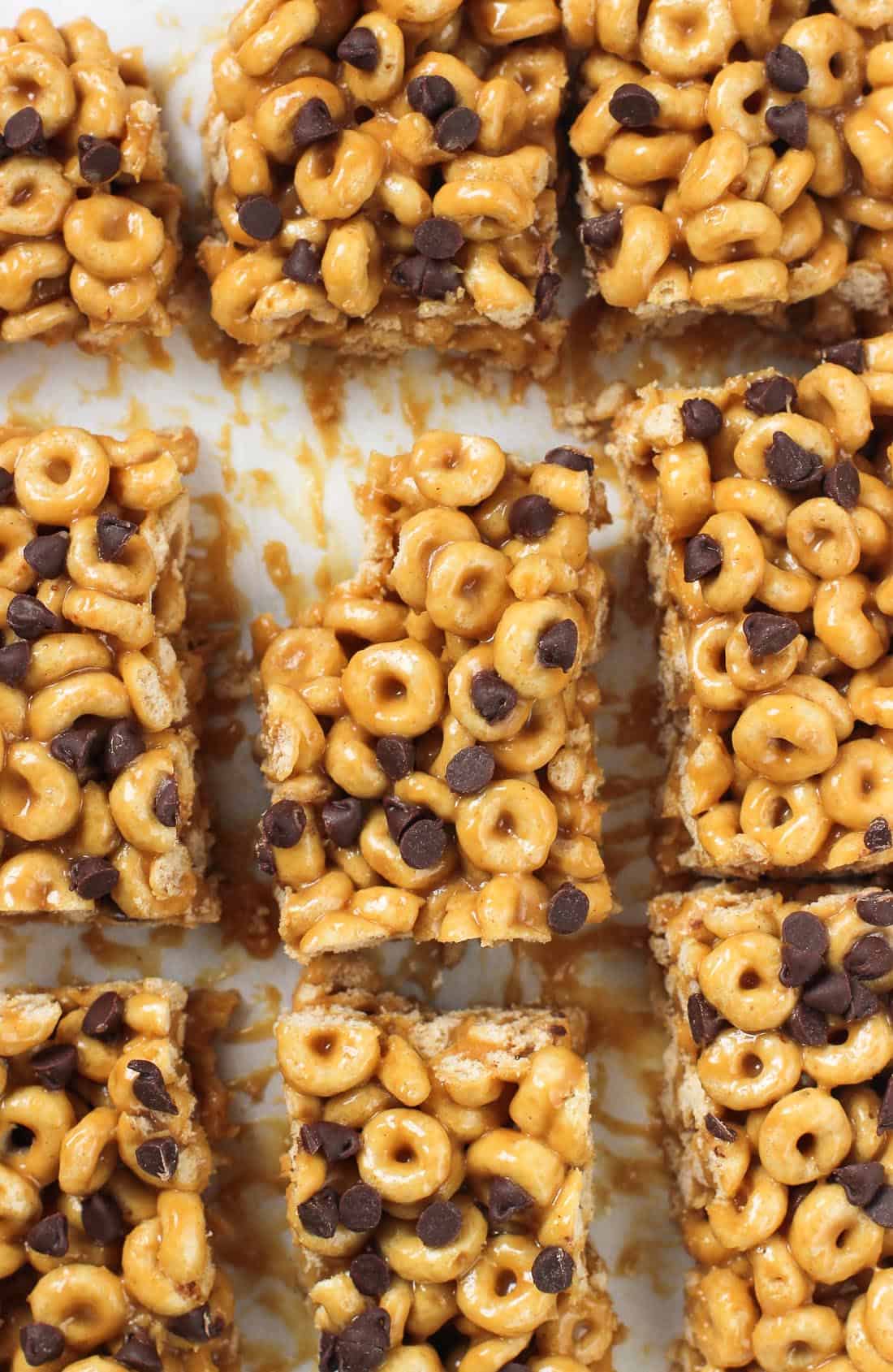 An overhead shot of cereal bars sliced on a board with a bite taken out of the corner of the middle bar