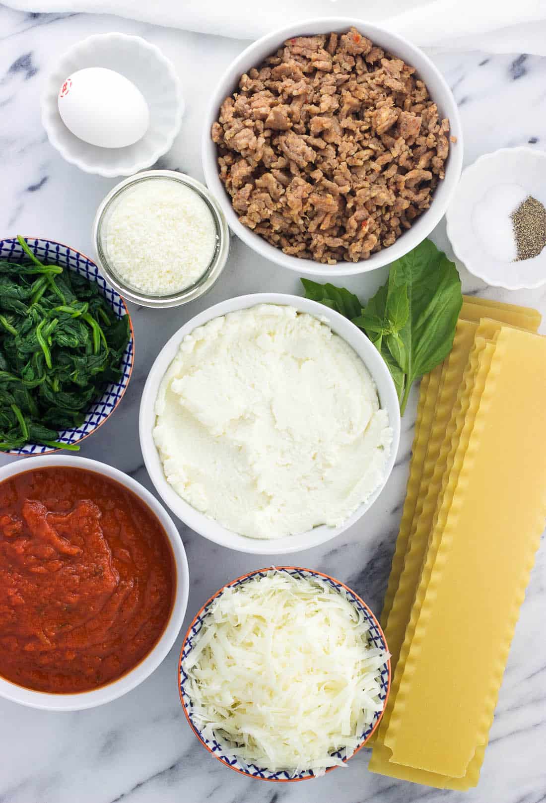 An overhead shot of lasagna roll ingredients in separate bowls