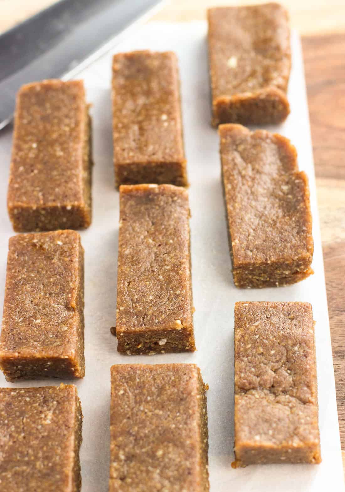 Sliced coconut almond bars lined up on a piece of parchment