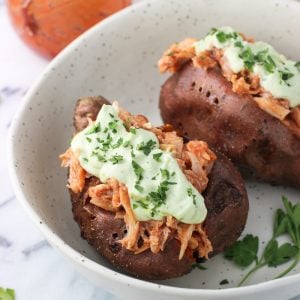 Two stuffed sweet potatoes in a bowl.