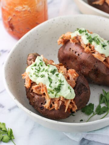 Two stuffed sweet potatoes in a bowl.