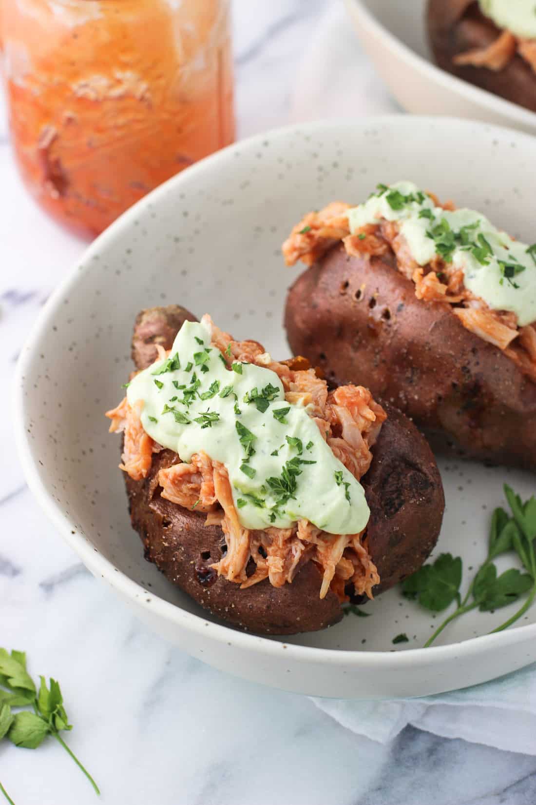 Two stuffed sweet potatoes in a bowl.