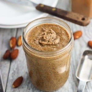 A clear glass jar of almond butter