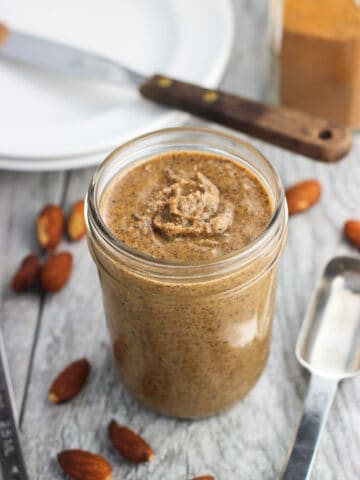 A clear glass jar of almond butter