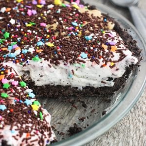 Ice cream pie in a glass pie plate with a piece removed.