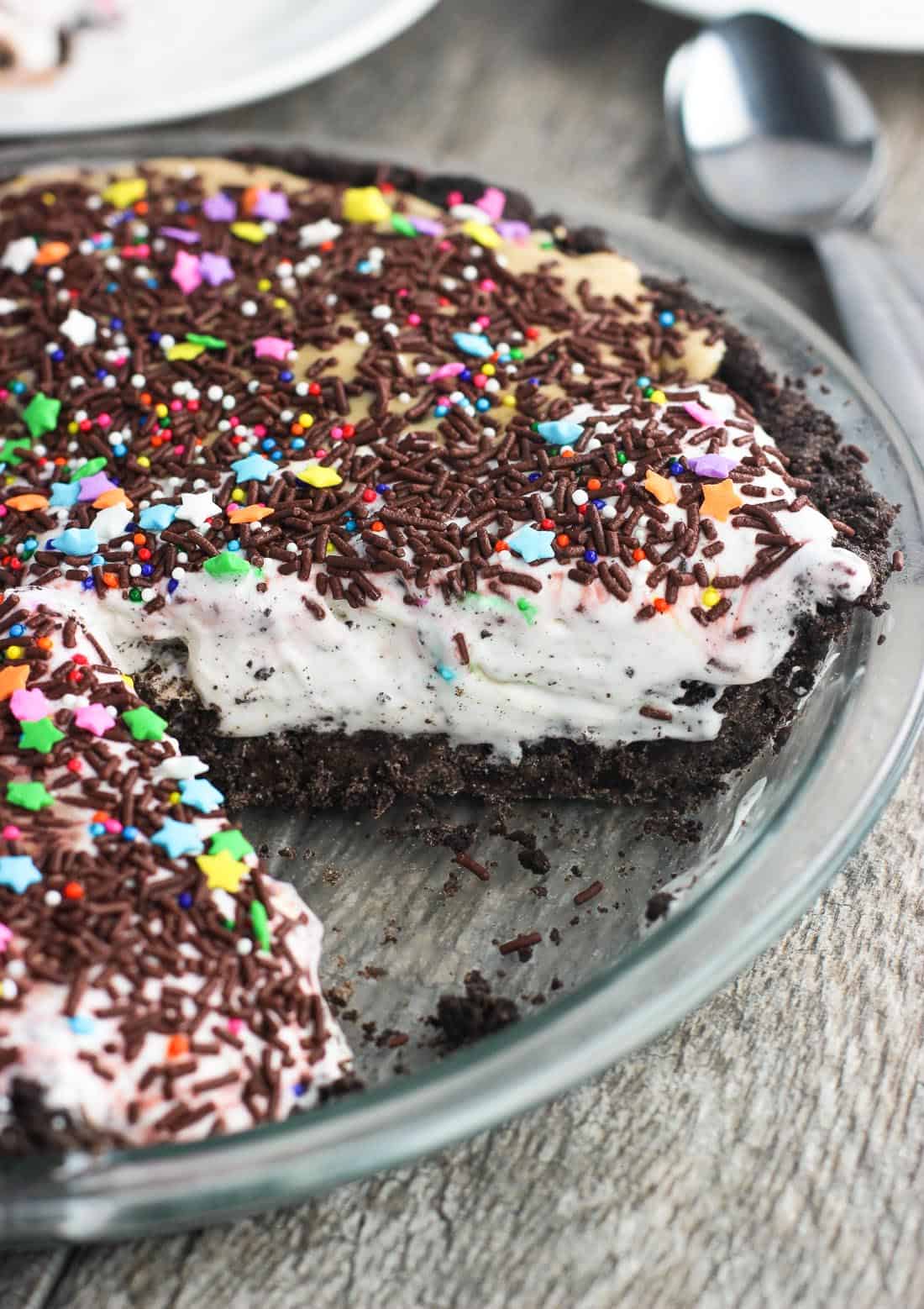 Ice cream pie in a glass pie plate with a piece removed.