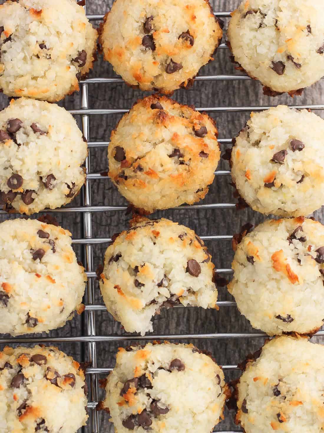 An overhead picture of a batch of macaroons on a wire cooling rack with one of the macaroons having a bite taken out of it