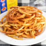 A heap of Old Bay seasoned curly fries on a plate.