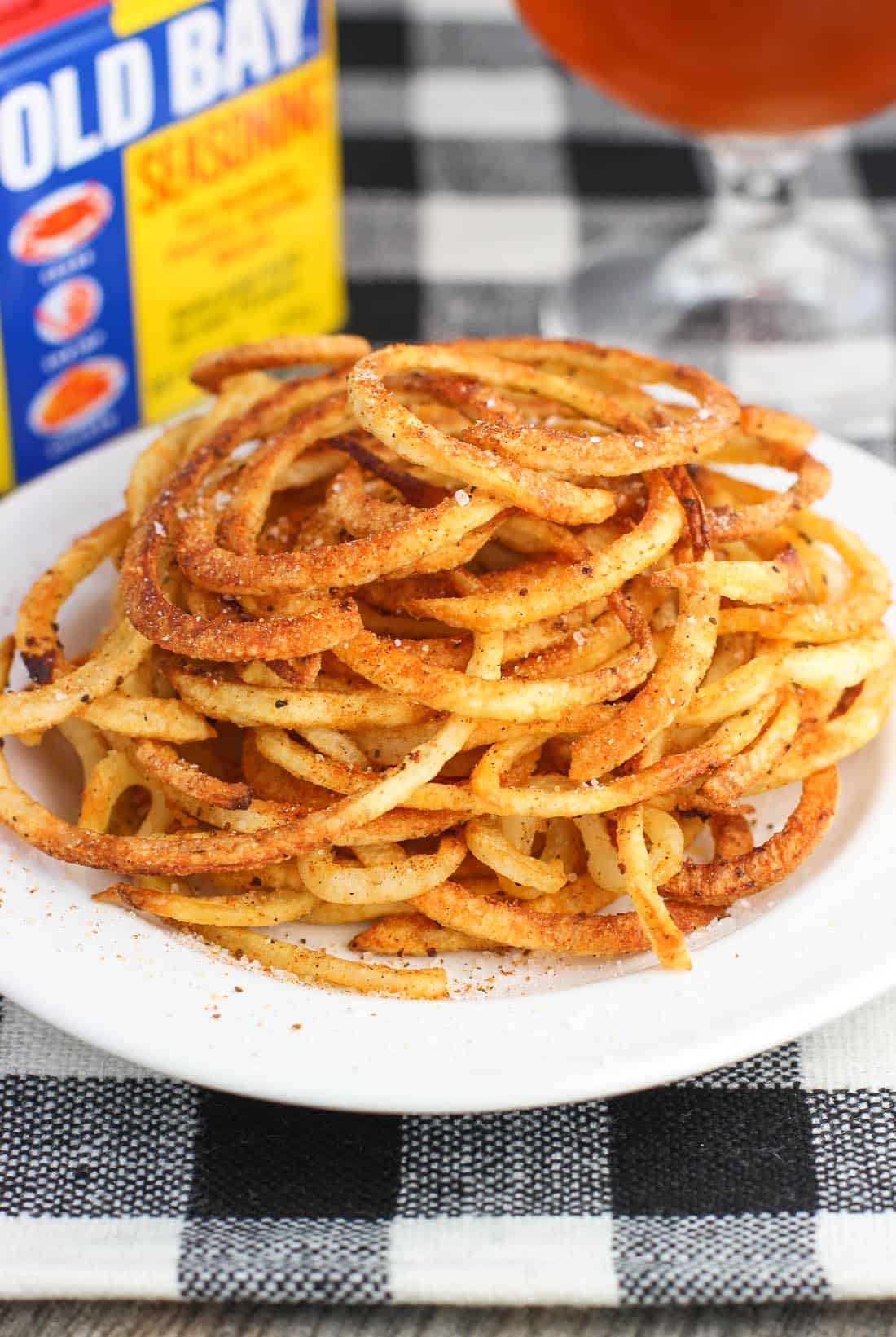 A heap of Old Bay seasoned curly fries on a plate.