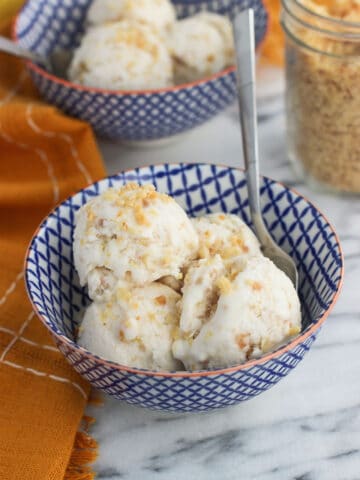 A bowl with several small scoops of ice cream with a spoon.