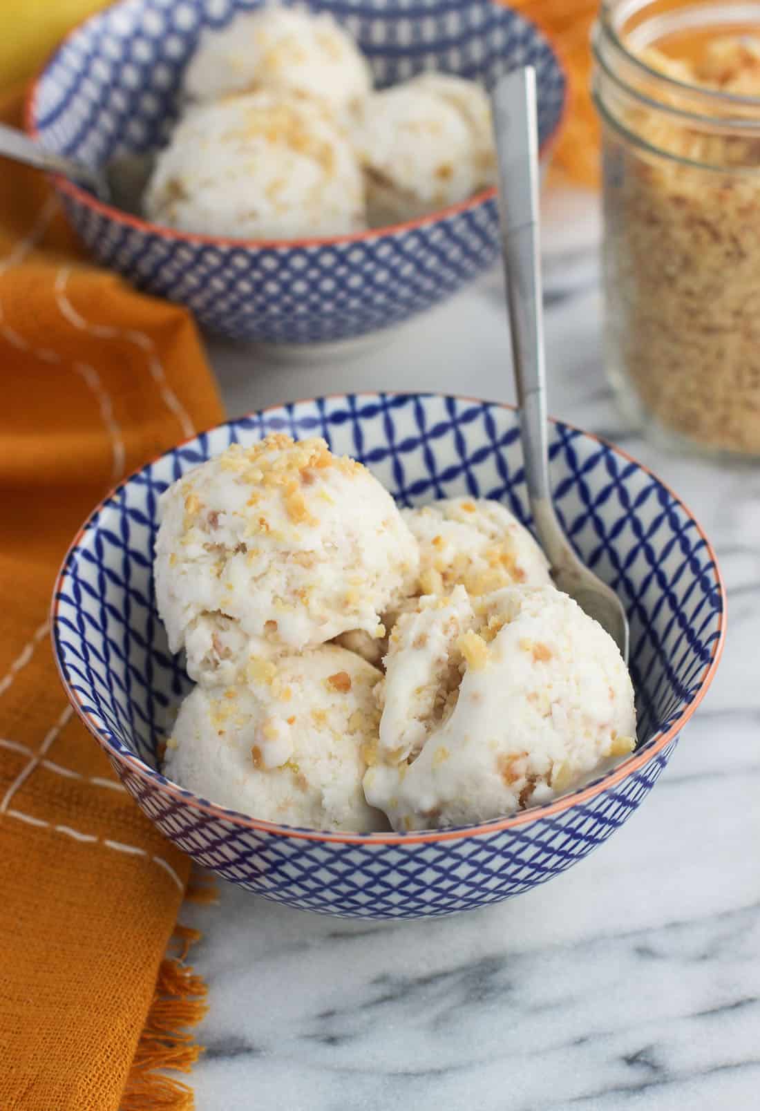 A bowl with several small scoops of ice cream with a spoon.