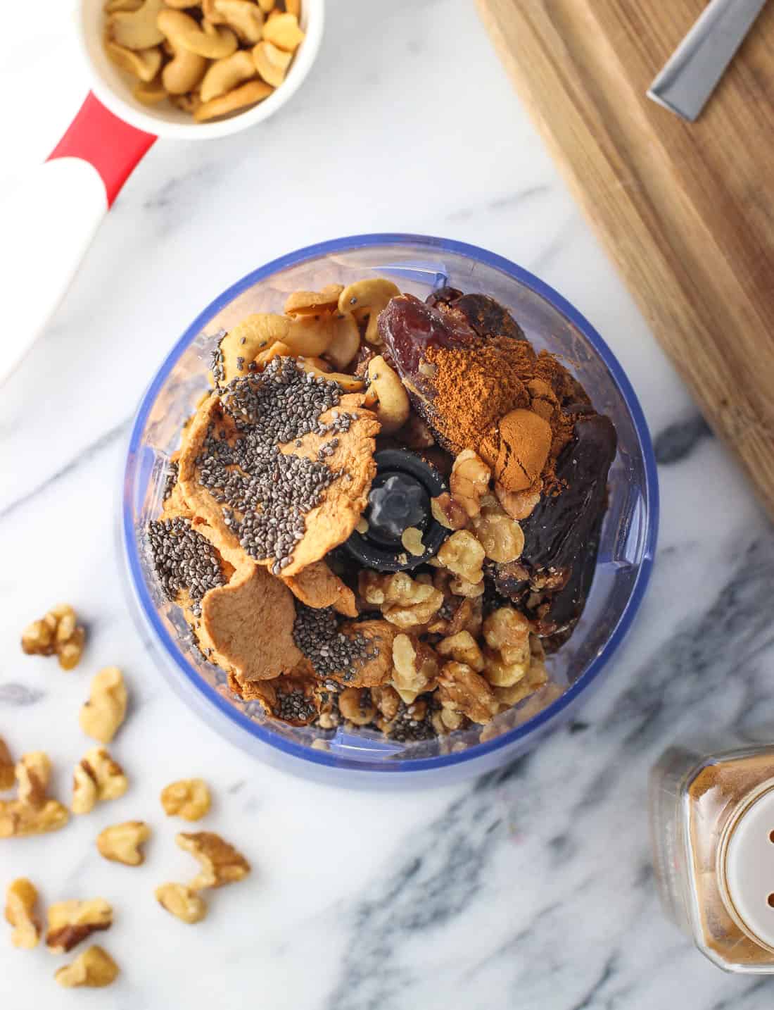 Chia bar ingredients in the bowl of a food processor before blending.