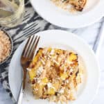 A serving of angel food cake, grilled pineapple, coconut, and caramel sauce on a dessert plate.