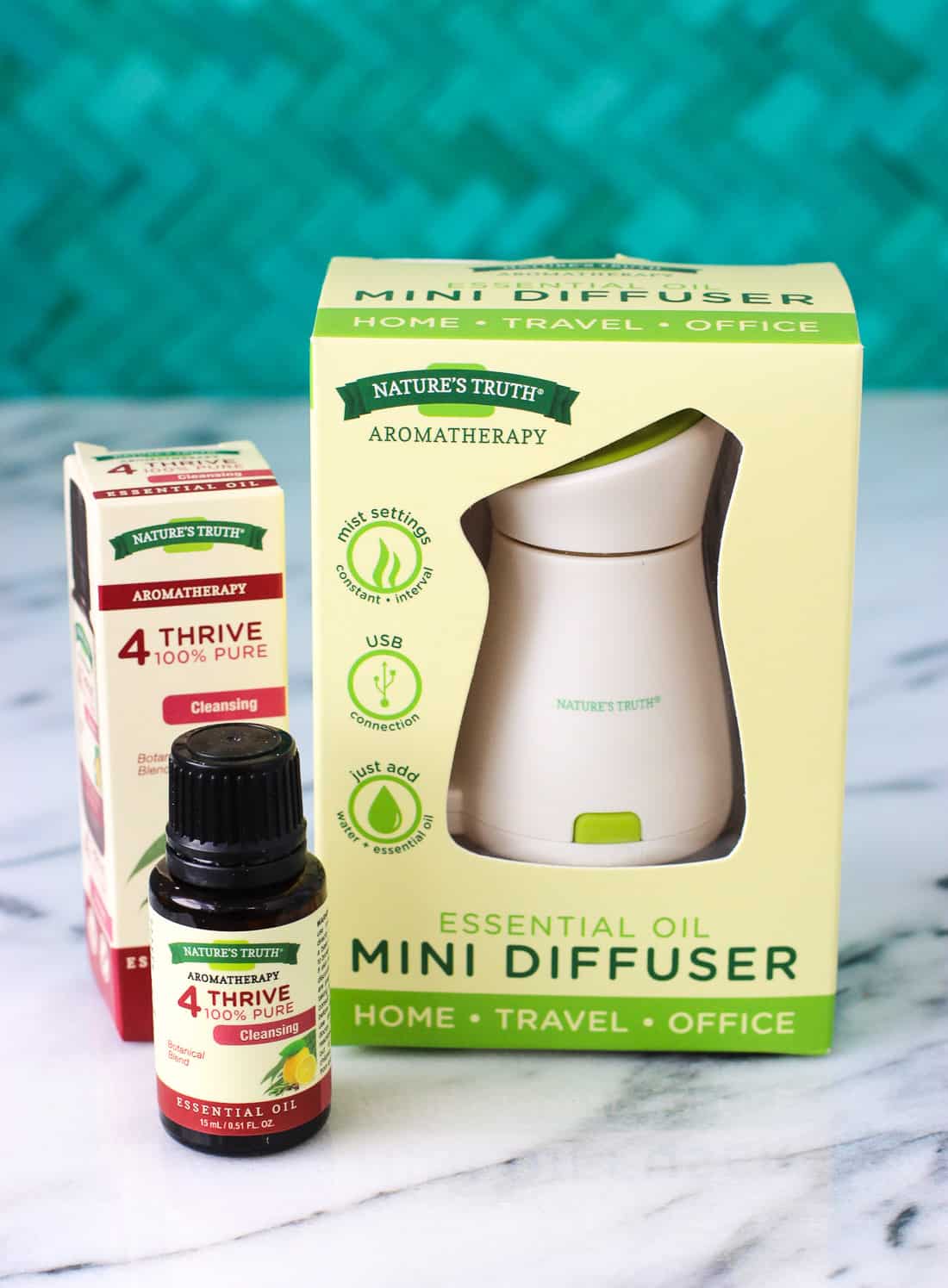 A Nature\'s Truth mini diffuser on a table next to a bottle of scented oil.