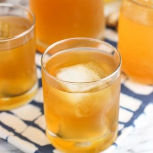 Glasses of iced green tea on a cloth placemat in front of a full carafe of tea