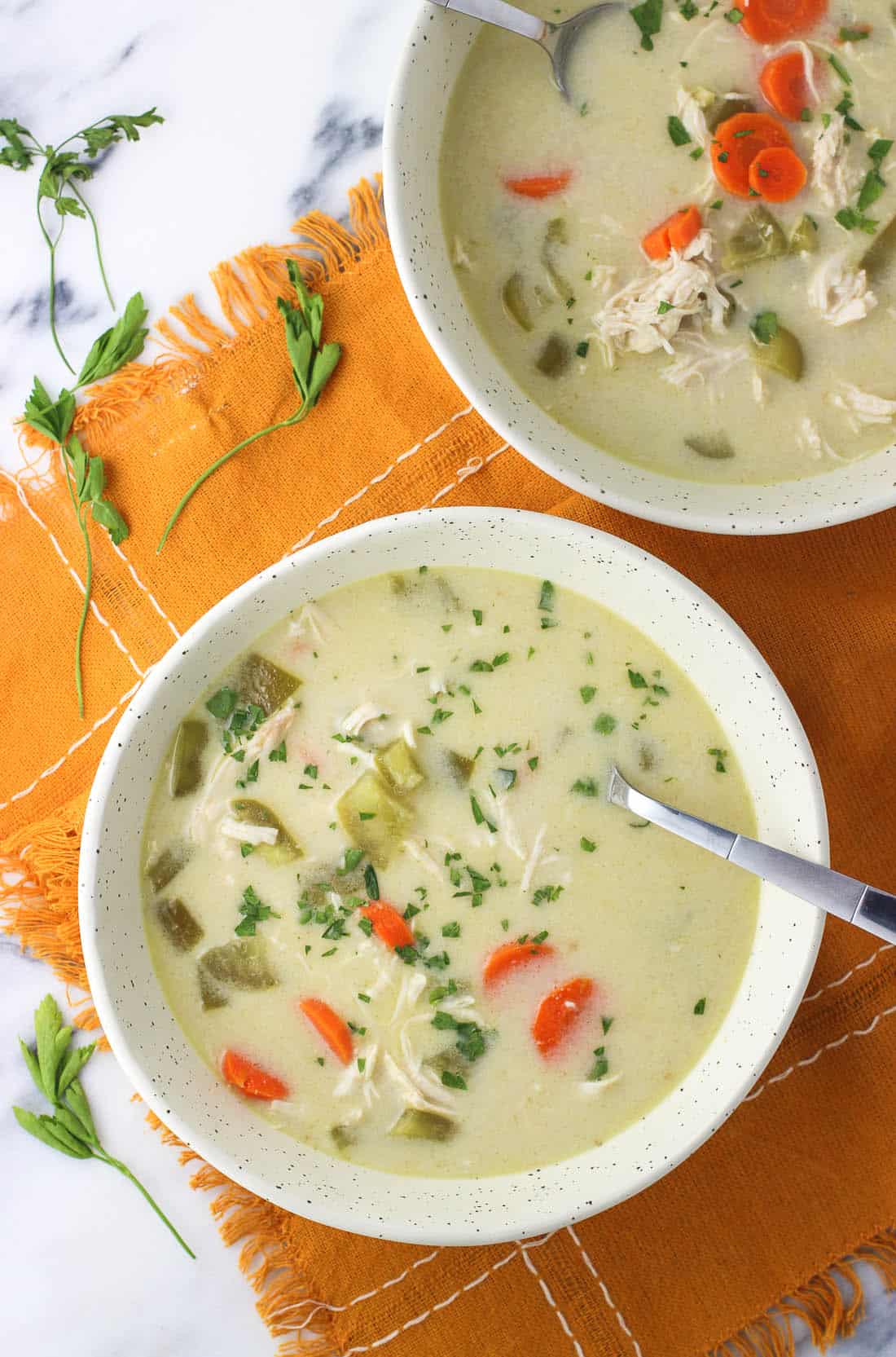 Two bowls of soup on a linen placemat.