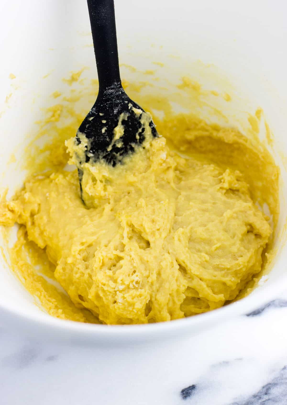 Struffoli dough in a medium mixing bowl with a spatula