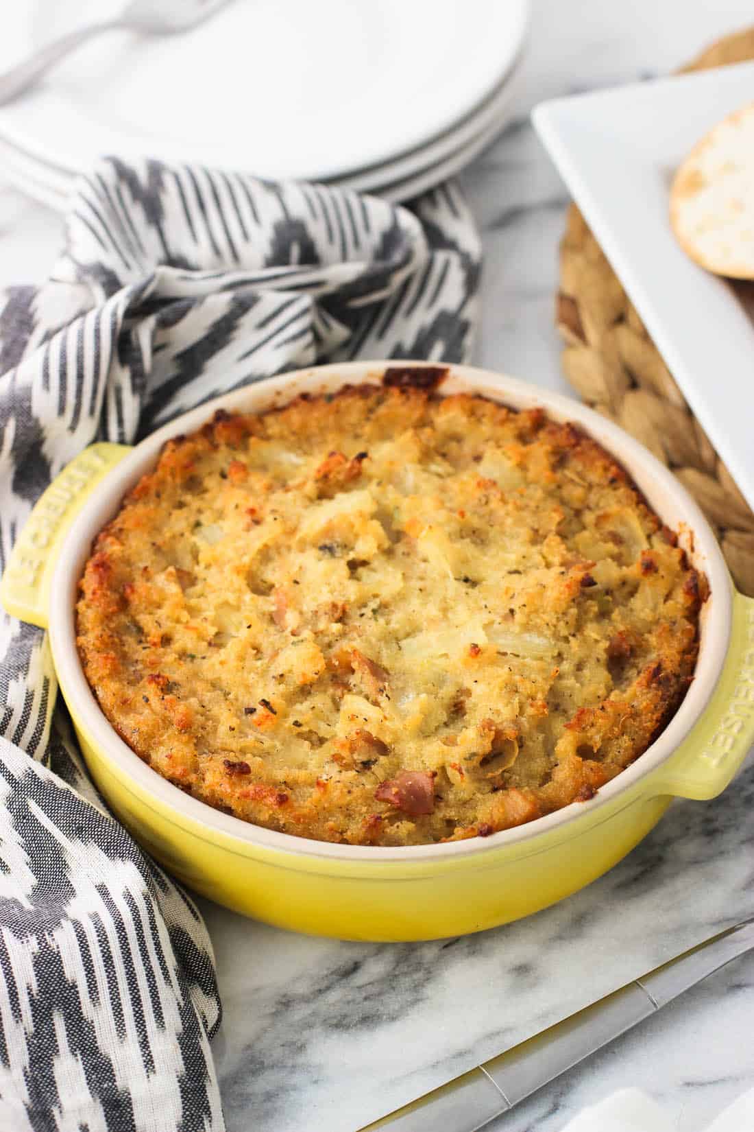 A small round baking dish filled with baked clam dip.