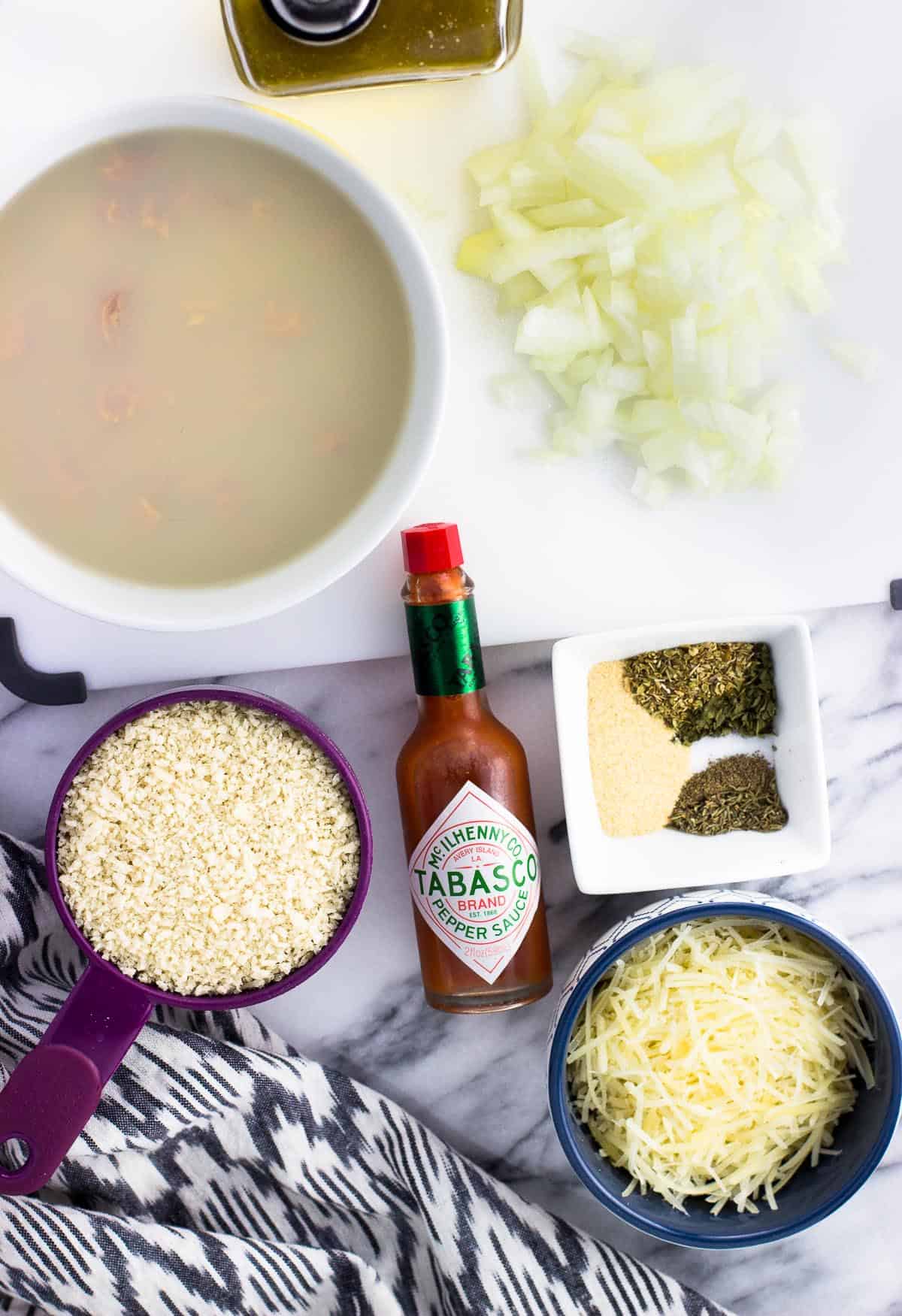 Recipe ingredients in separate bowls and containers on a marble board.