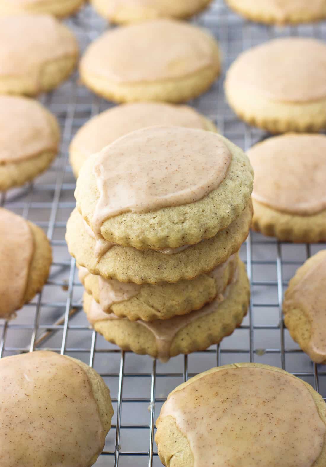 A stack of sugar cookies on a wire rack covered in icing.