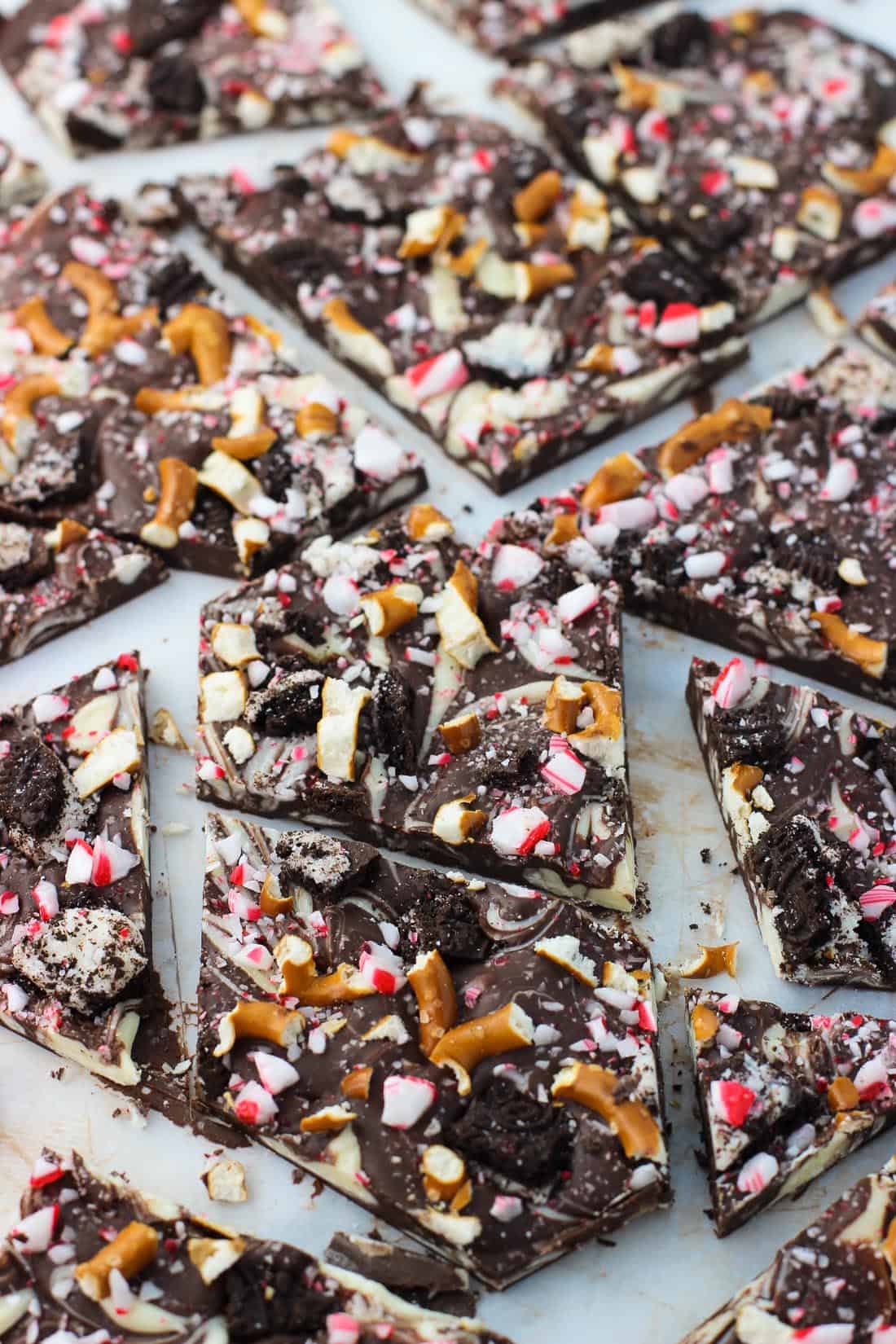 Pieces of peppermint bark in a single layer on a sheet of parchment paper