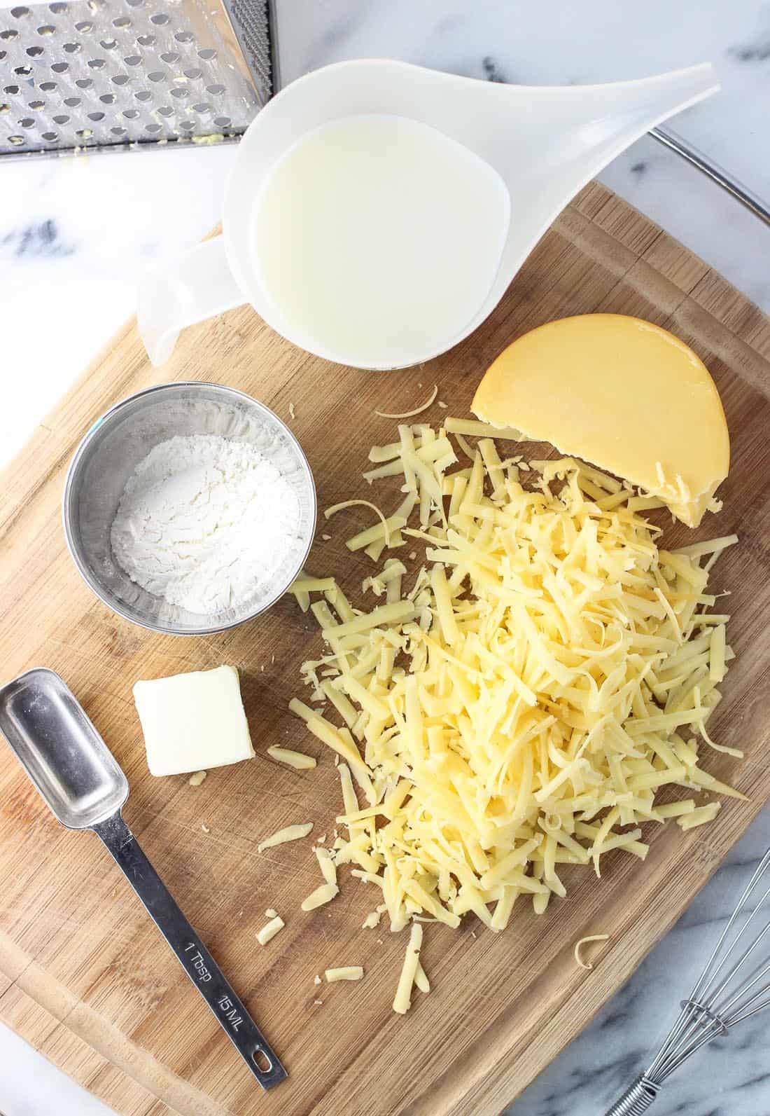 The gouda dip ingredients on a wooden cutting board.