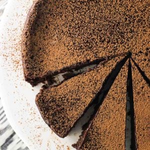 An overhead shot of the cake on a ceramic cake stand, partially sliced into slightly narrow slices