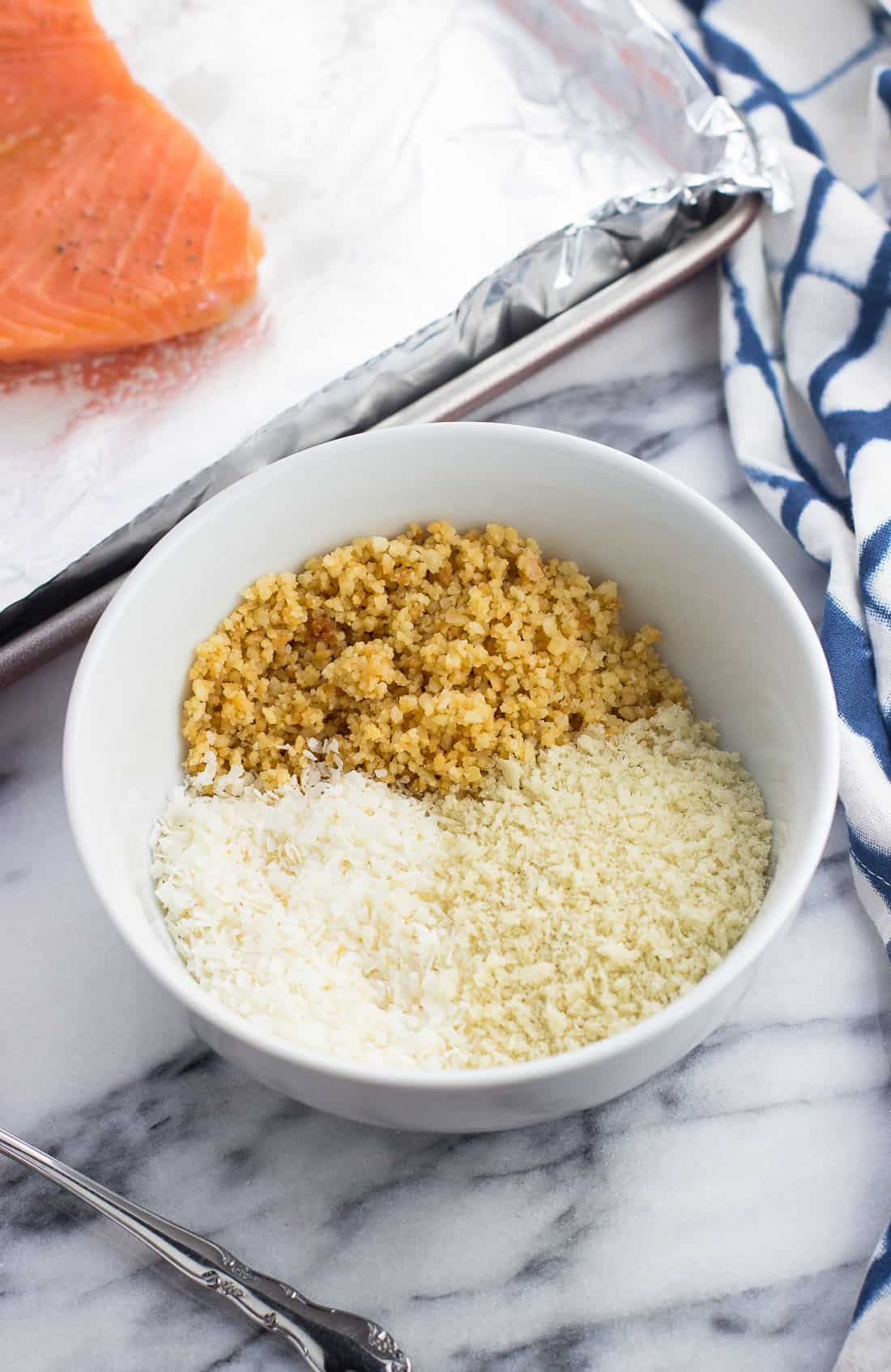 Ground macadamia nuts, unsweetened coconut flakes, and panko breadcrumbs in a bowl