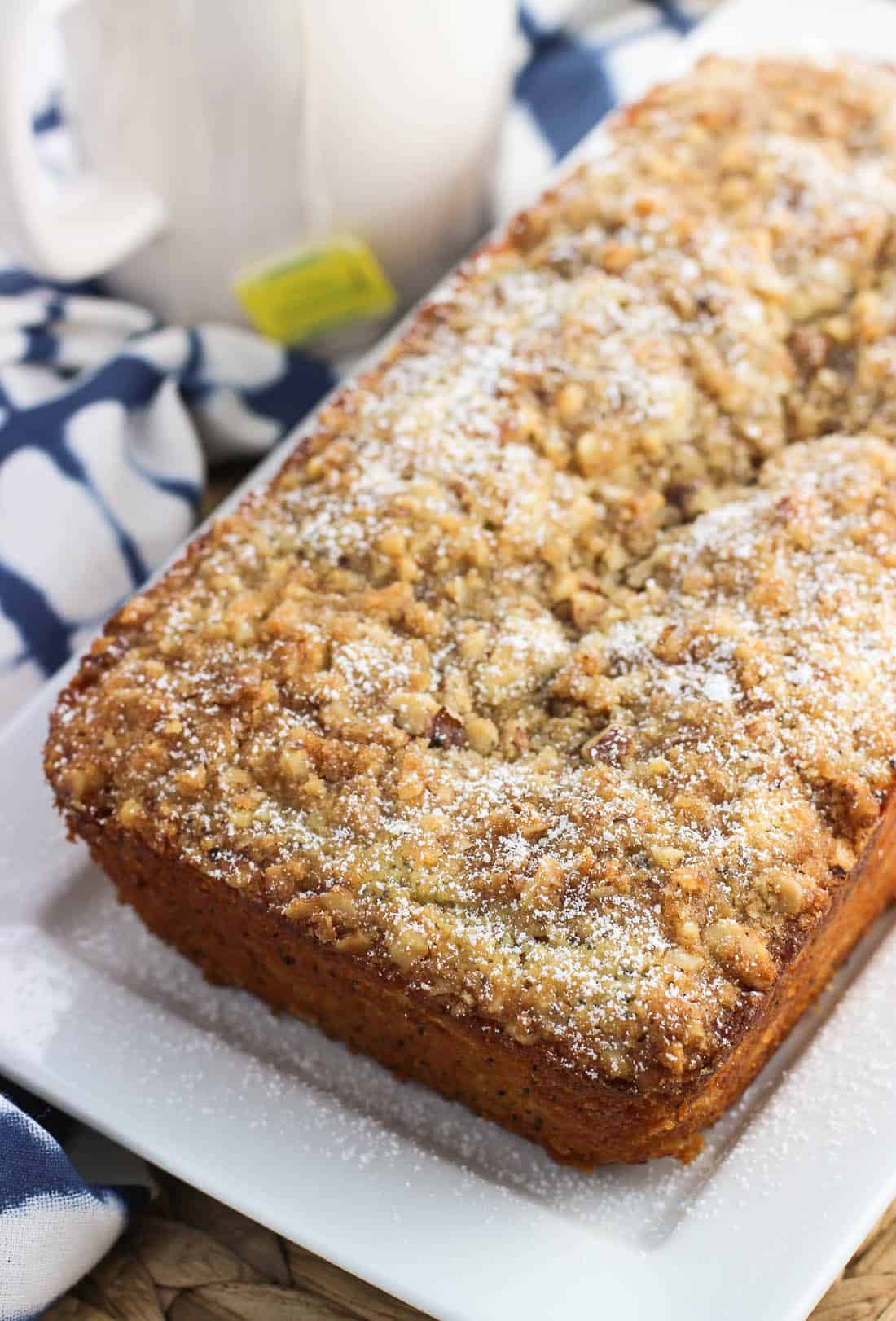 A loaf of lemon poppy seed bread topped with streusel and dusted with confectioners' sugar