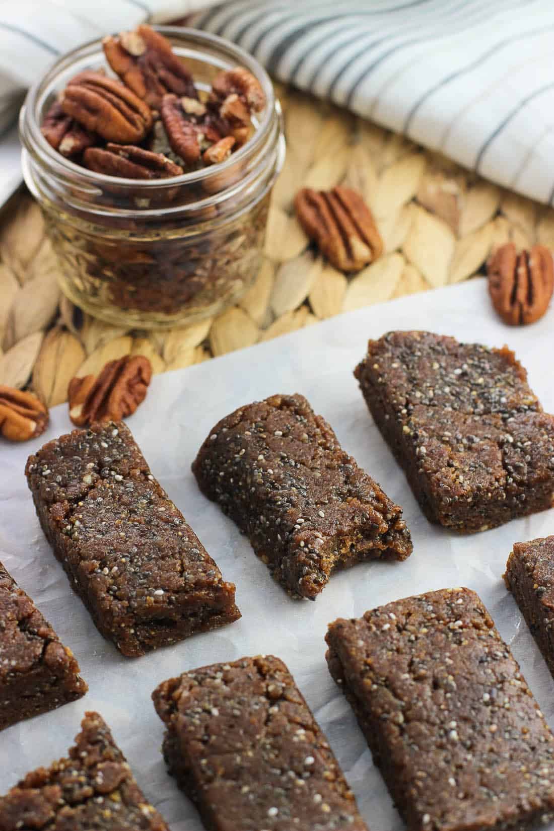 Sliced cinnamon pecan chia bars on a sheet of parchment paper.